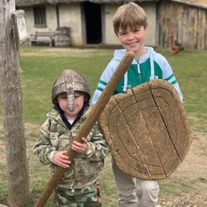 two boys at Mountfitchet Castle with Knights Helmet and shield