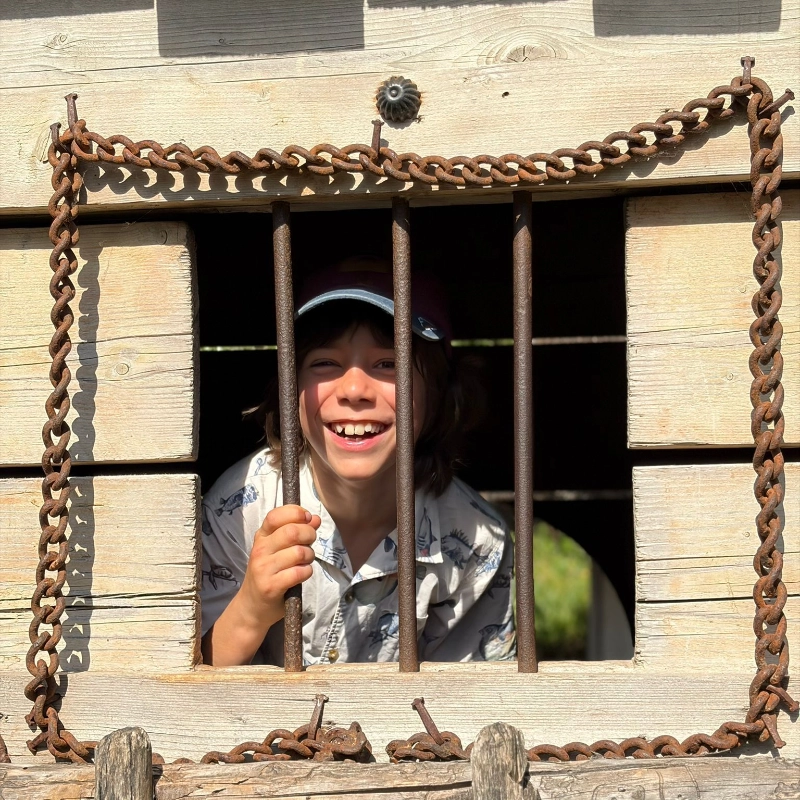 Boy behind bared windows at Mountfitchet Castle